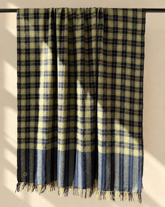 AJAX Pashmina aus Ladakhi Kaschmir mit marineblau-olivfarbenen Karos, gelben Linien und Fransen, über eine Stange gelegt.
