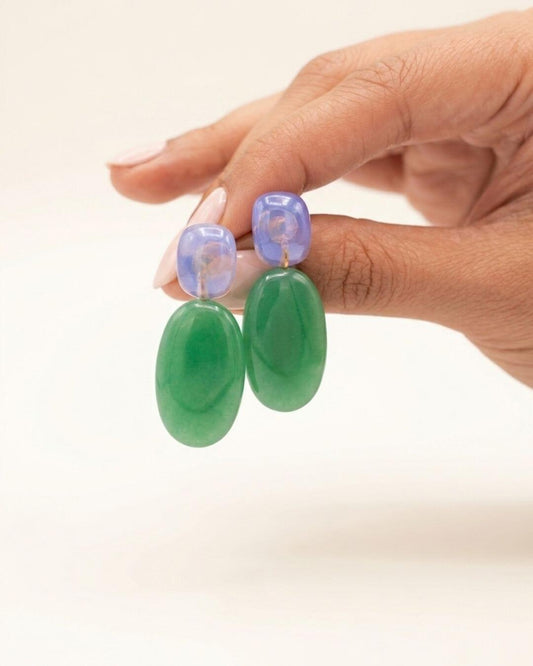 ALMA Ohrring mit lavendelfarbenem Chalcedon-Stecker und ovalem grünem Chalcedon-Anhänger am Ohr bei offenem blondem Haar.