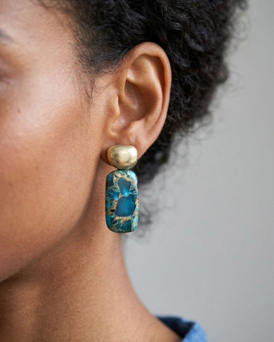 ANJA Ohrring mit Pyrit-Stecker und länglichem blauem Kupfer-Türkis mit goldfarbenen Adern, am Ohr getragen.