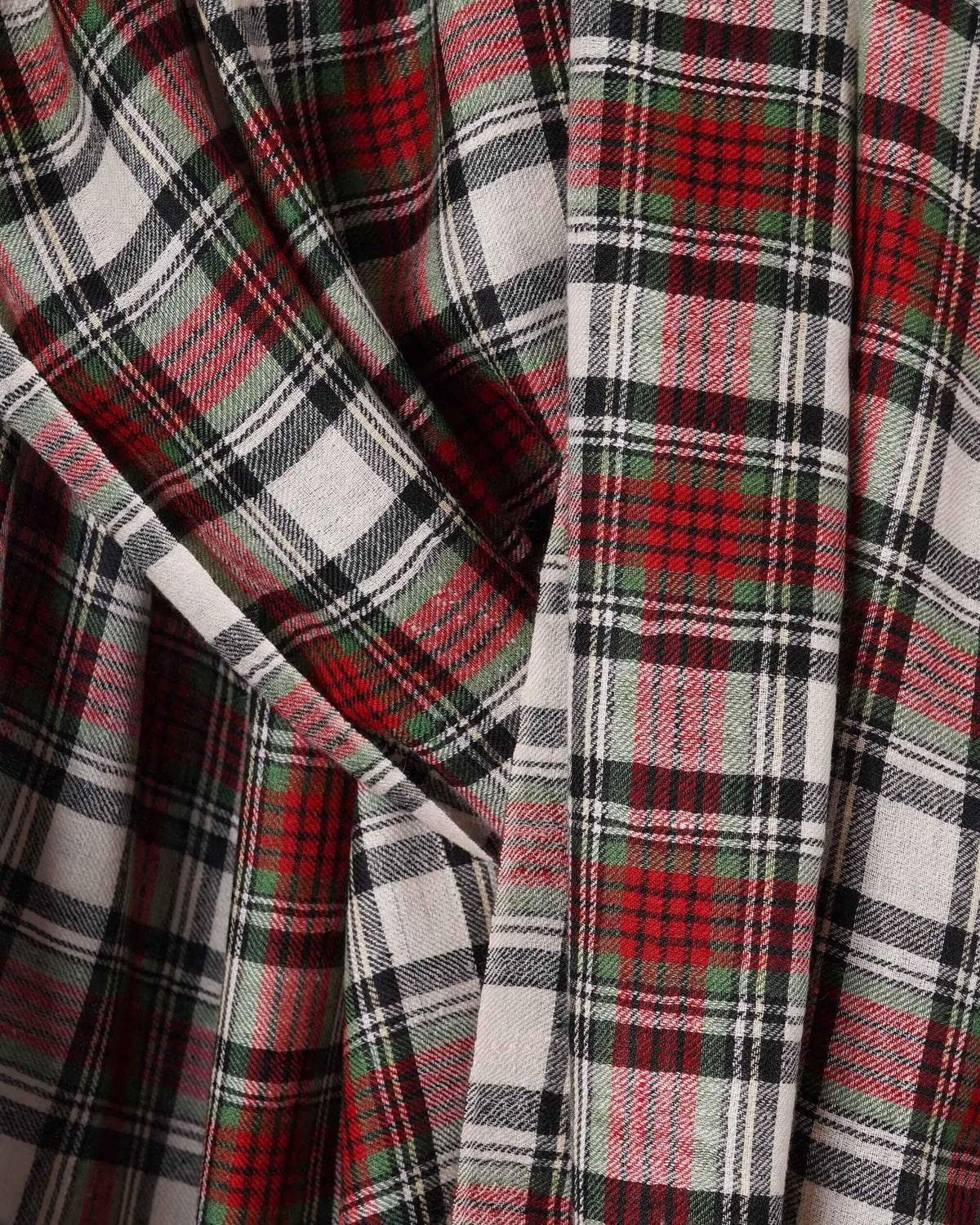 Nahaufnahme des BLAIR Pashmina mit feinem Diagonalgewebe und Karos in Rot, Creme, Dunkelgrün und Schwarz.