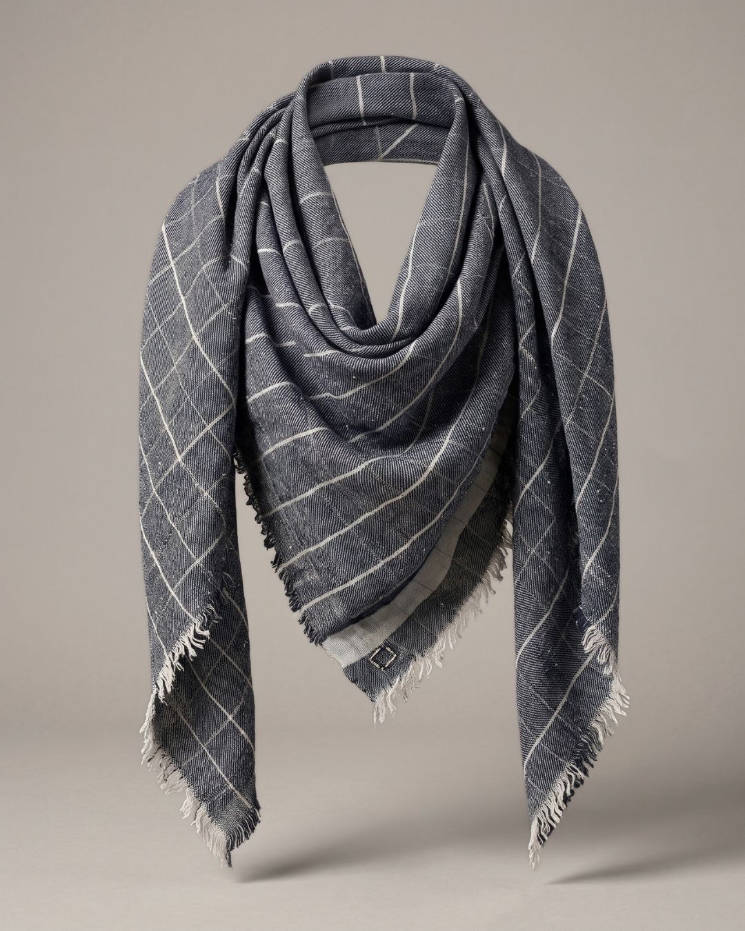 Graues CHAYE Pashmina-Foulard locker drapiert, mit silberfarbenen Karos, heller Bordüre und kurzen Fransen.