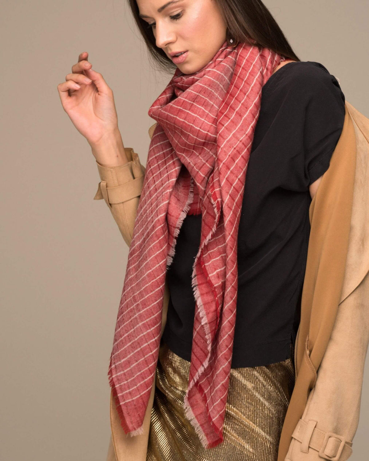 CHAYE Pashmina aus Ladakhi Kaschmir und Lurex in Rot, locker getragen zum schwarzen Oberteil und camelfarbenen Mantel.