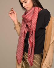 Load image into Gallery viewer, CHAYE Pashmina aus Ladakhi Kaschmir und Lurex in Rot, locker getragen zum schwarzen Oberteil und camelfarbenen Mantel.
