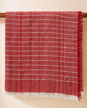 Load image into Gallery viewer, CHAYE Pashmina aus Ladakhi Kaschmir und Lurex in Rot, über einer Holzstange mit hellen Fransen und Rautenstickerei.
