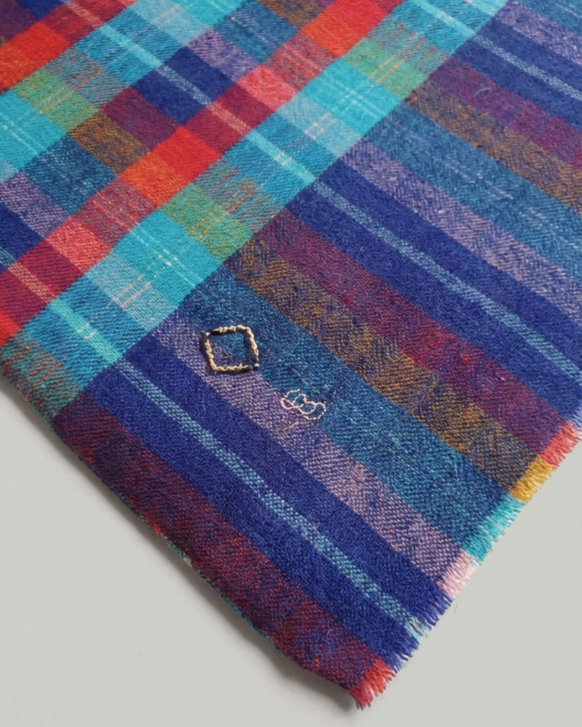 DARCI Pashmina aus Ladakhi Kaschmir, Detail der bunten Karos, blauen Streifenborde und kurzen Fransenkante.