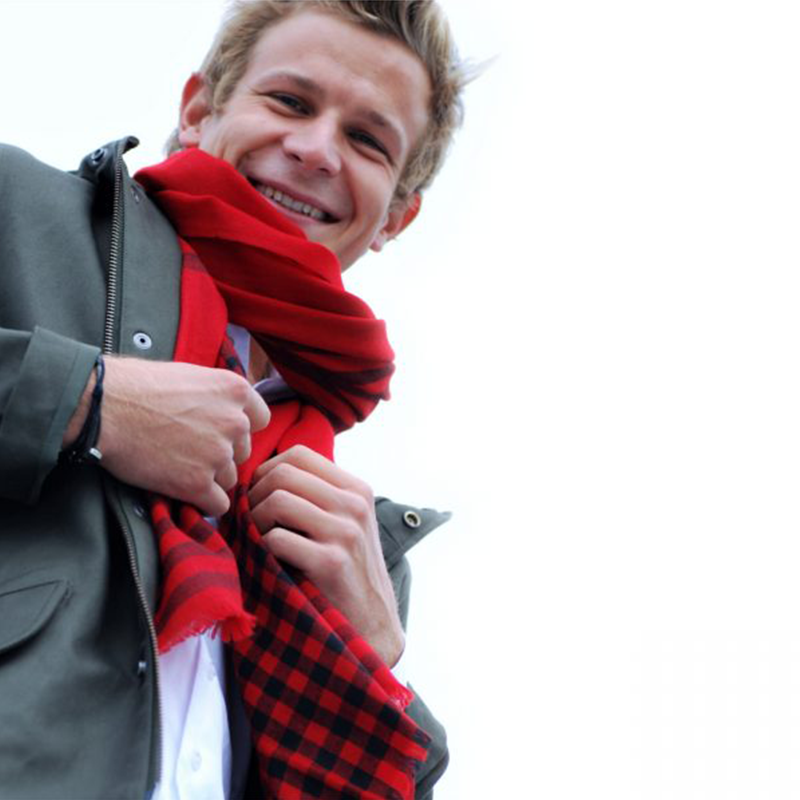 DIARMID Kaschmir Schal in Rot und Schwarz, locker um den Hals zu dunkler Jacke und weissem Hemd getragen.