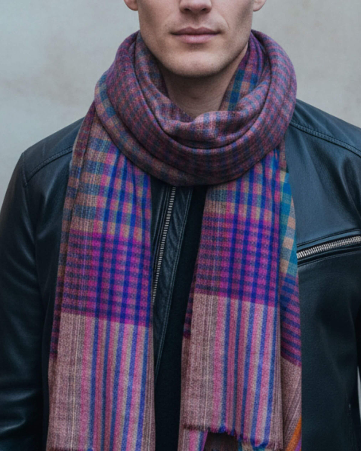 FEZZ Pashmina-Schal in Türkis und Violett, locker um den Hals getragen zu einer schwarzen Lederjacke.
