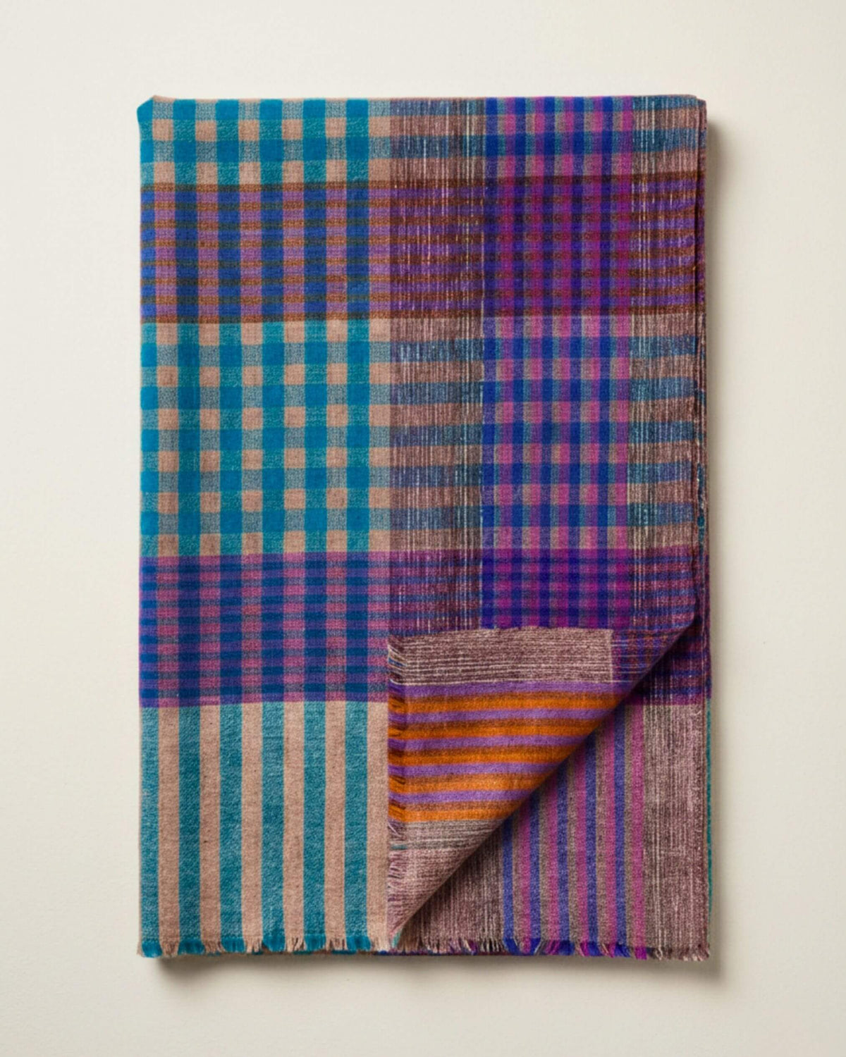 FEZZ Pashmina-Schal gefaltet, mit Karos in Türkis und Violett, orangefarbenen Akzenten und umgeschlagener Ecke.