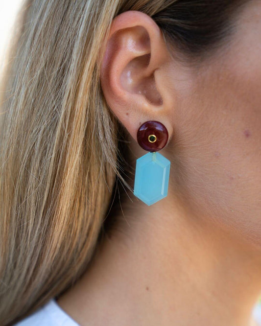 FREYA Ohrring am Ohr mit geometrischem Aqua-Chalcedon-Anhänger und rotem Jaspis-Oberteil mit grüner Onyx-Einlage.