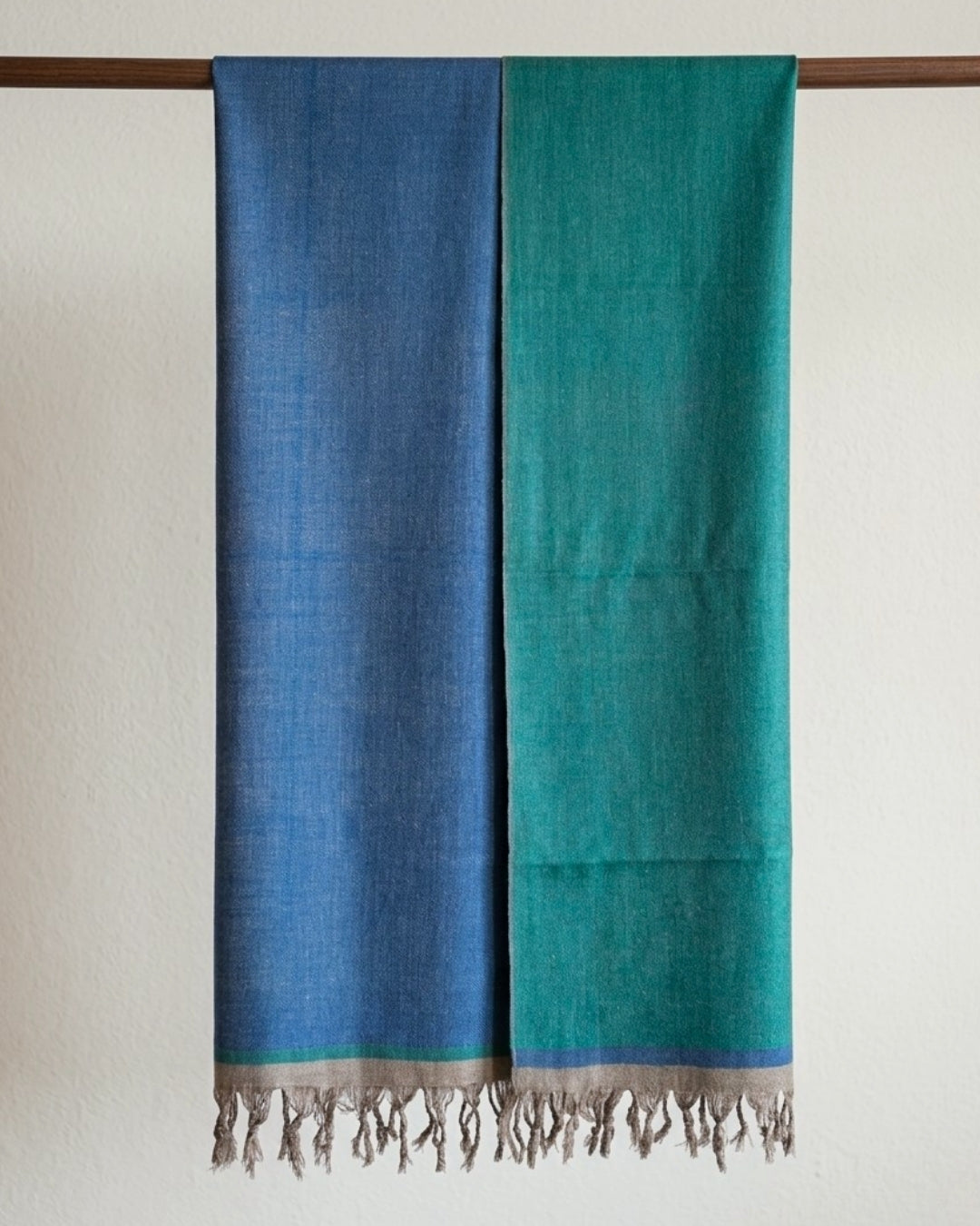 GURU Pashmina in Blau und Grün mit beigen Fransen, über eine Holzstange gelegt, beide Seiten sichtbar.