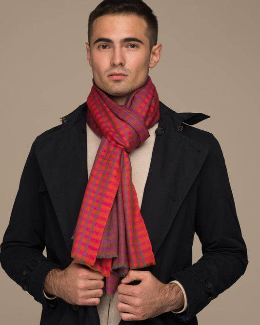 HARI Pashmina in Pink, Orange und Violett, an einem männlichen Model zu einem dunklen Mantel getragen.