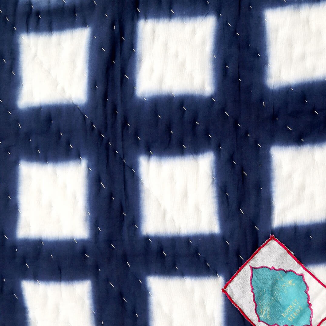 Nahaufnahme des modernen Gitter-Musters der Indigo Decke – präzise Handarbeit kombiniert mit zeitlosem blauen Design.