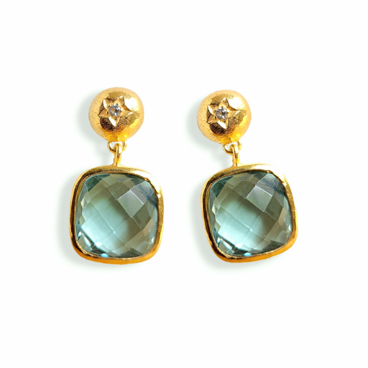 IZARE Ohrringe mit kissenförmigem grünem Amethyst und weissem Topas in goldfarbenen Steckern auf weissem Hintergrund.