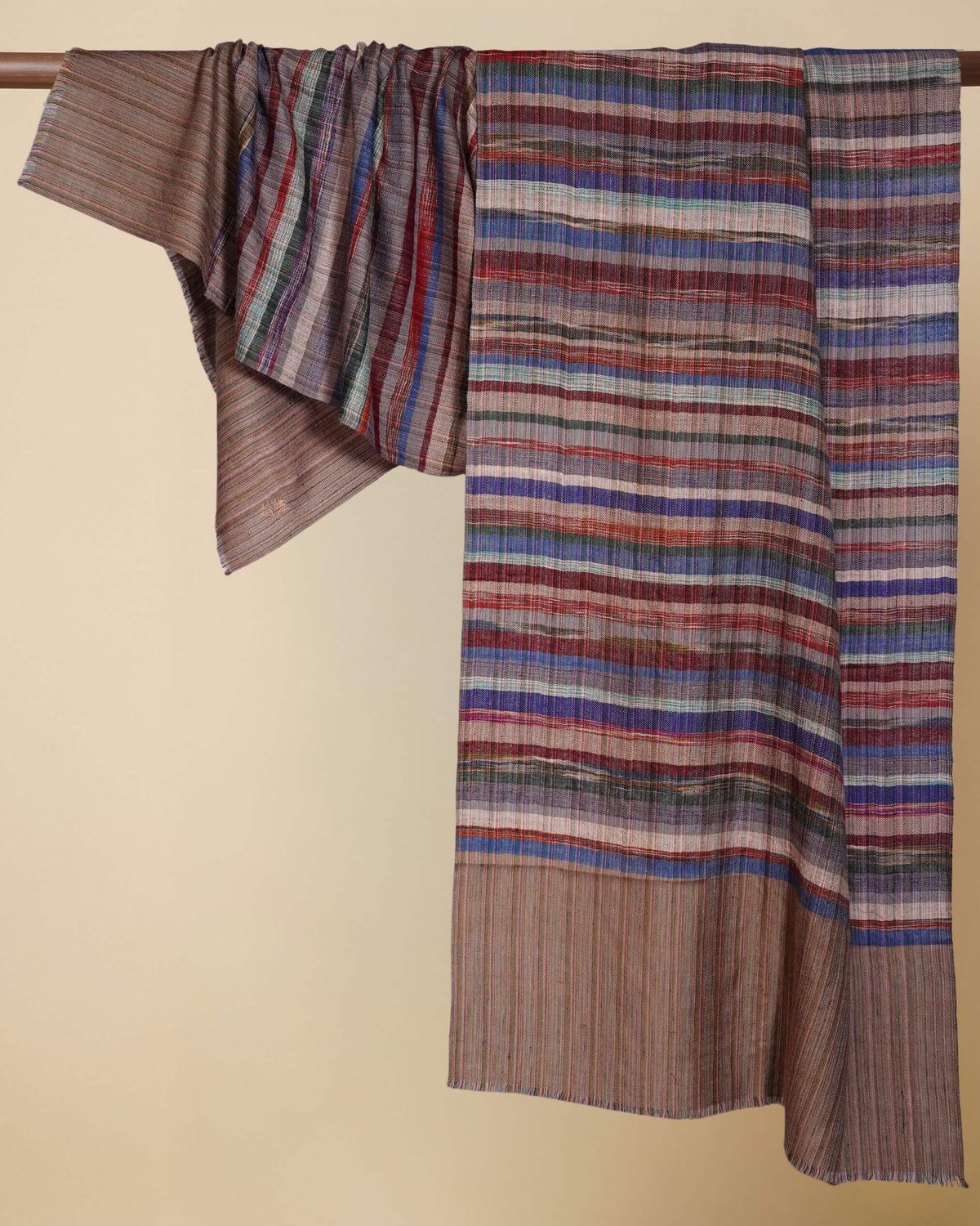 LENNON Pashmina über einer Holzstange drapiert, mit mehrfarbigen Streifen auf Taupe und abgesetzten Endpartien