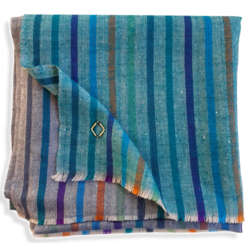 ROME Pashmina aus Ladakhi Kaschmir, gefaltet mit türkisfarbenen Partien, bunten Längsstreifen und kurzen Fransen.
