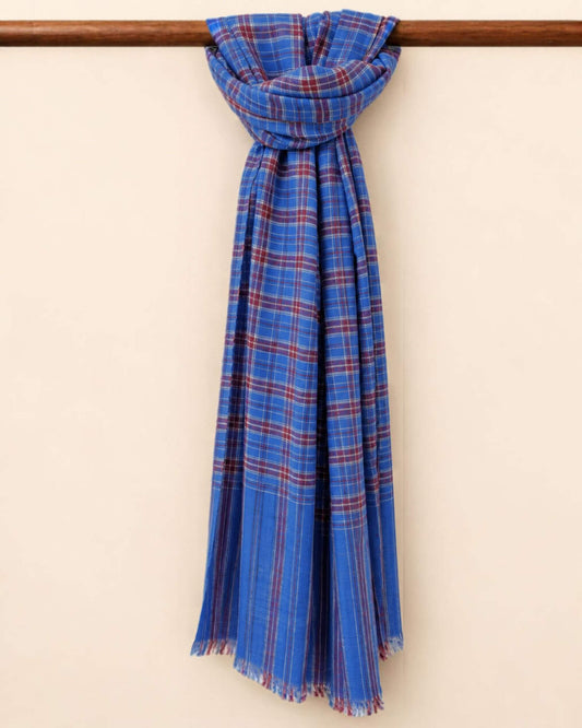 SHEA Pashmina Kaschmir Schal in Blau mit burgunderroten und weissen Karos, an einer Holzstange geknotet.