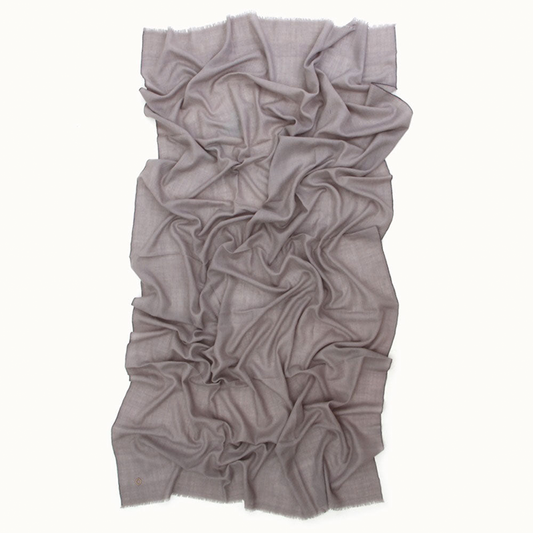 ZAMARID Pashmina-Schal in Grau, längs ausgebreitet und in weichen Falten auf Weisser Hintergrund drapiert.