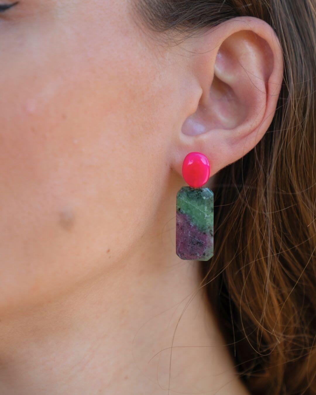 ZIVA Ohrring mit fuchsiafarbenem Chalcedon und grün-violett gemustertem Rubin-Zoisit, seitlich am Ohr bei offenem Haar gezeigt.