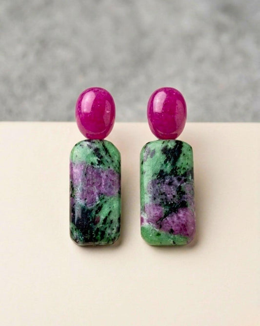 ZIVA Ohrringe mit ovalen fuchsiafarbenen Chalcedon-Oberteilen und rechteckigen Rubin-Zoisit-Anhängern in Grün, Violett und Schwarz auf hellem Hintergrund.